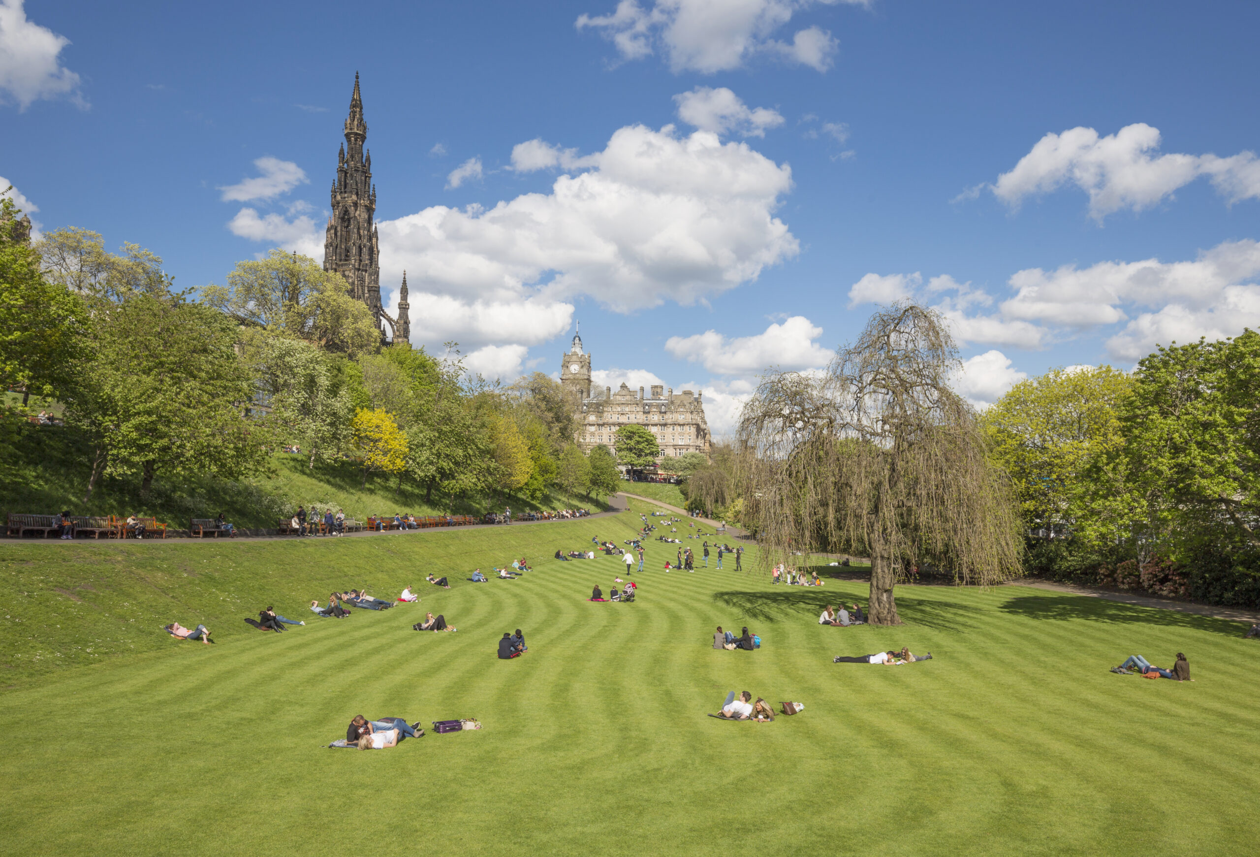 Edinburgh's Princes Street Gardens, a vibrant public park in the heart of the city, featuring beautiful gardens, walking paths, and the famous Scott Monument in the background. 