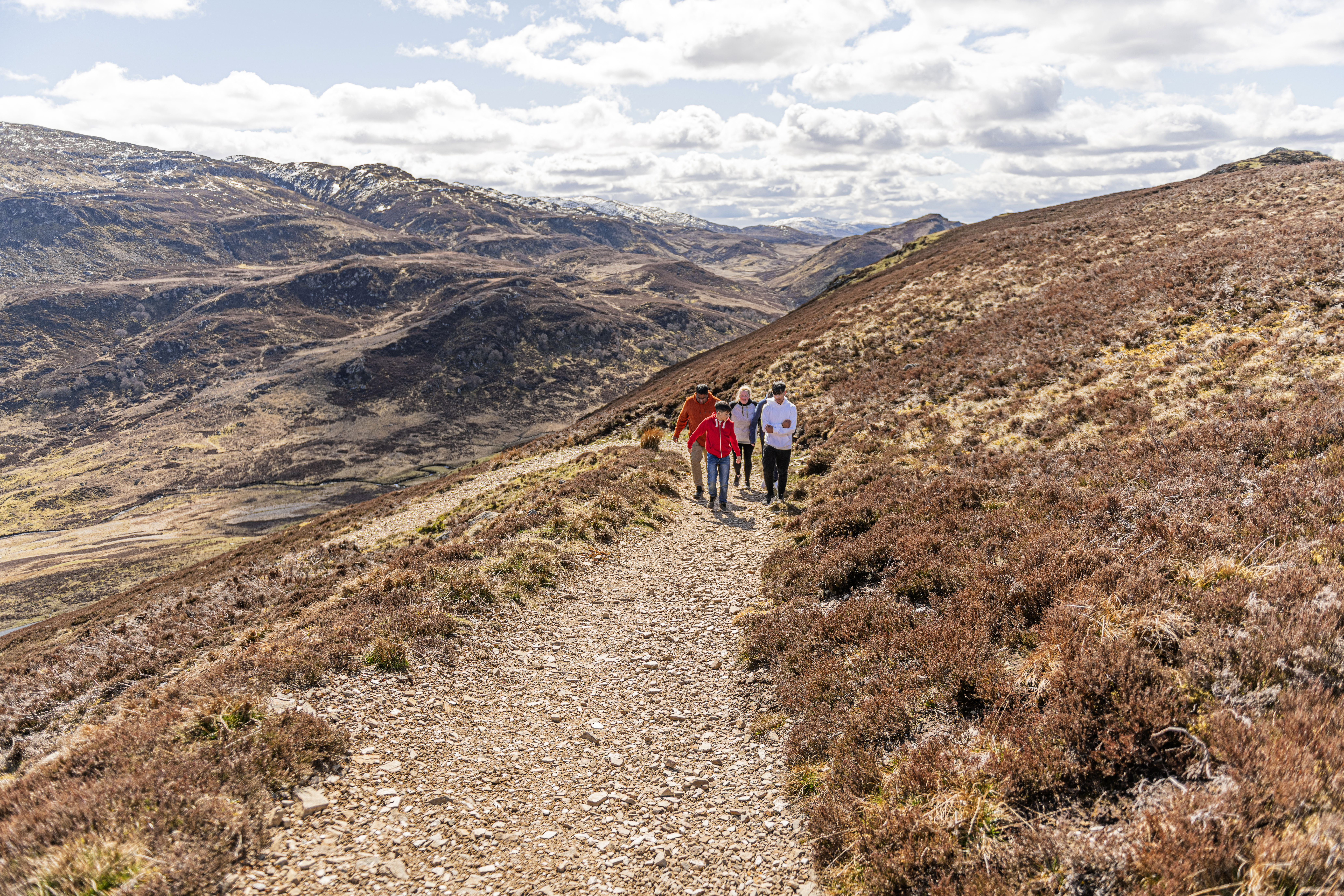 A panoramic photo from Suidhe Viewpoint, overlooking the scenic Fort Augustus and the southern end of Loch Ness in the Scottish Highlands, with rolling hills and mountains stretching out into the distance.