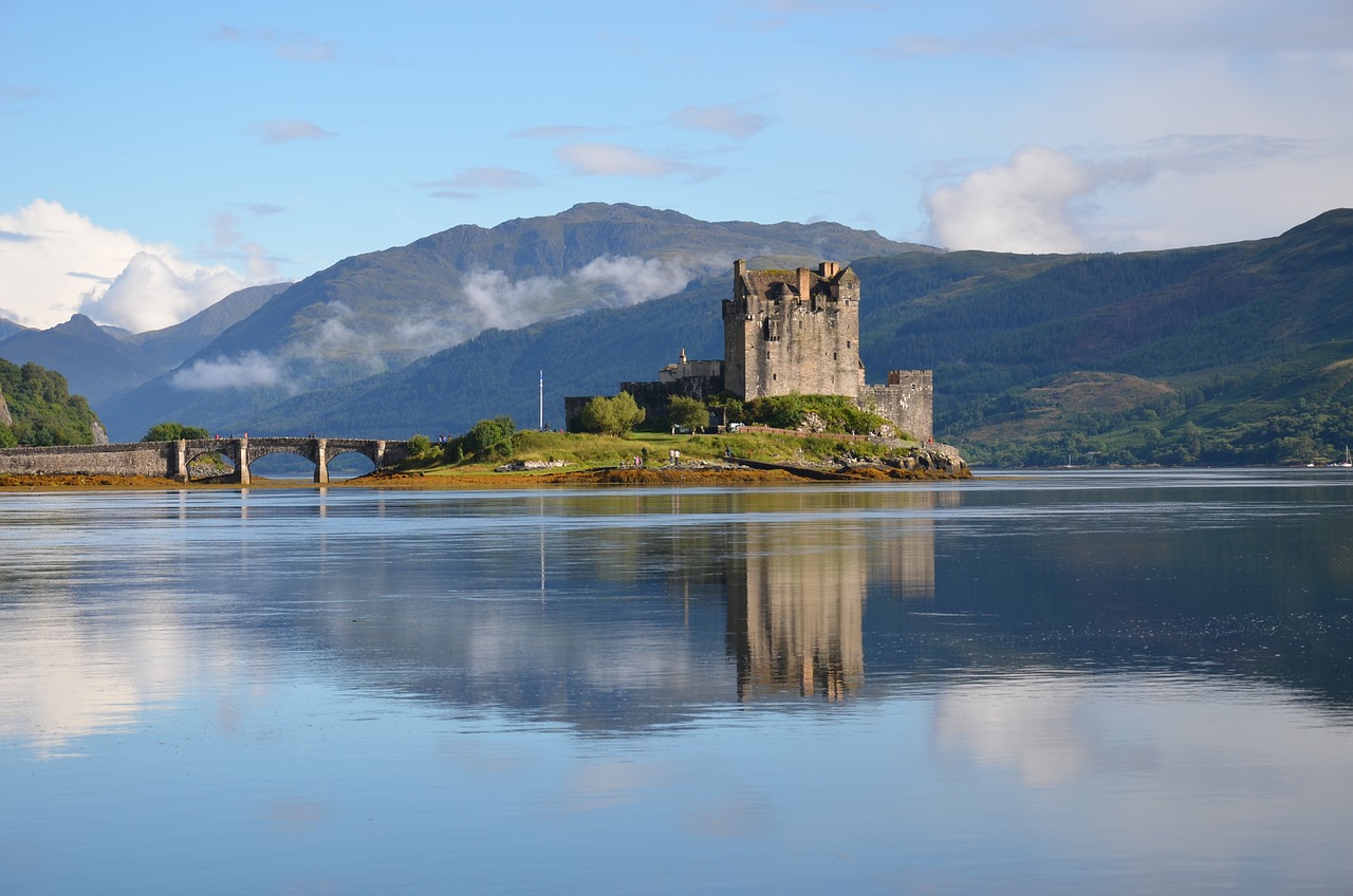 Eilean Donan Castle, a picturesque 13th-century fortress, sits on a small island in Loch Duich, Scotland, surrounded by majestic mountains and serene waters. 