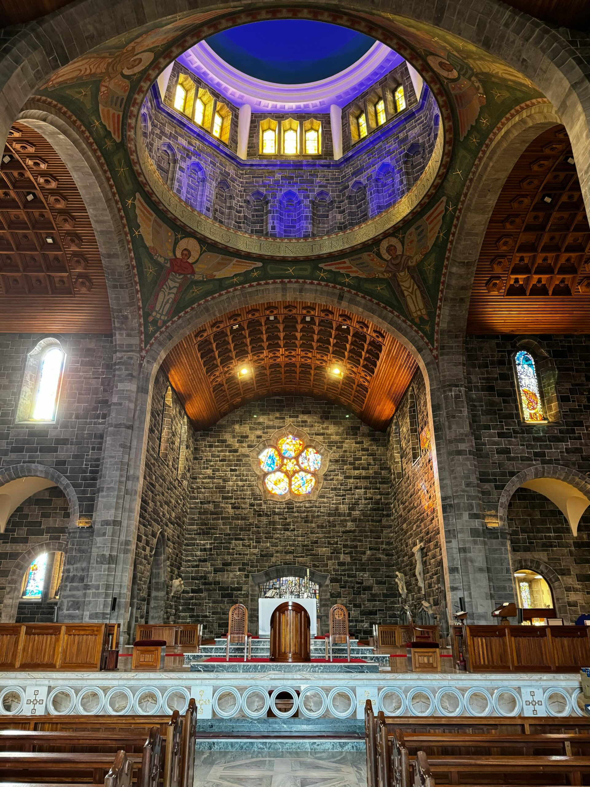 The stunning Galway Cathedral, also known as the Cathedral of Our Lady Assumed into Heaven and St. Nicholas, in Galway, Ireland, featuring a striking stone exterior with intricate carvings, towering spires, and a beautiful rose window. 