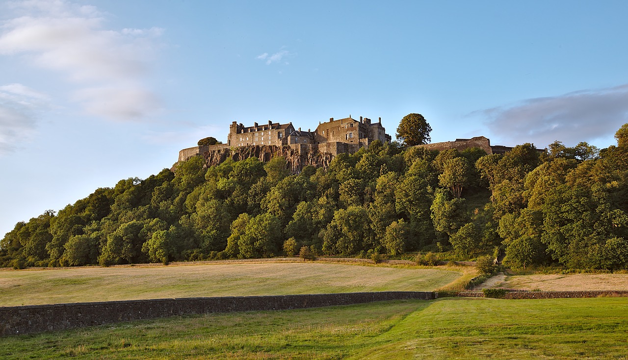 Stirling Castle, a historic royal residence in Scotland, sits atop a rocky outcrop, showcasing its imposing architecture and stunning surroundings. 