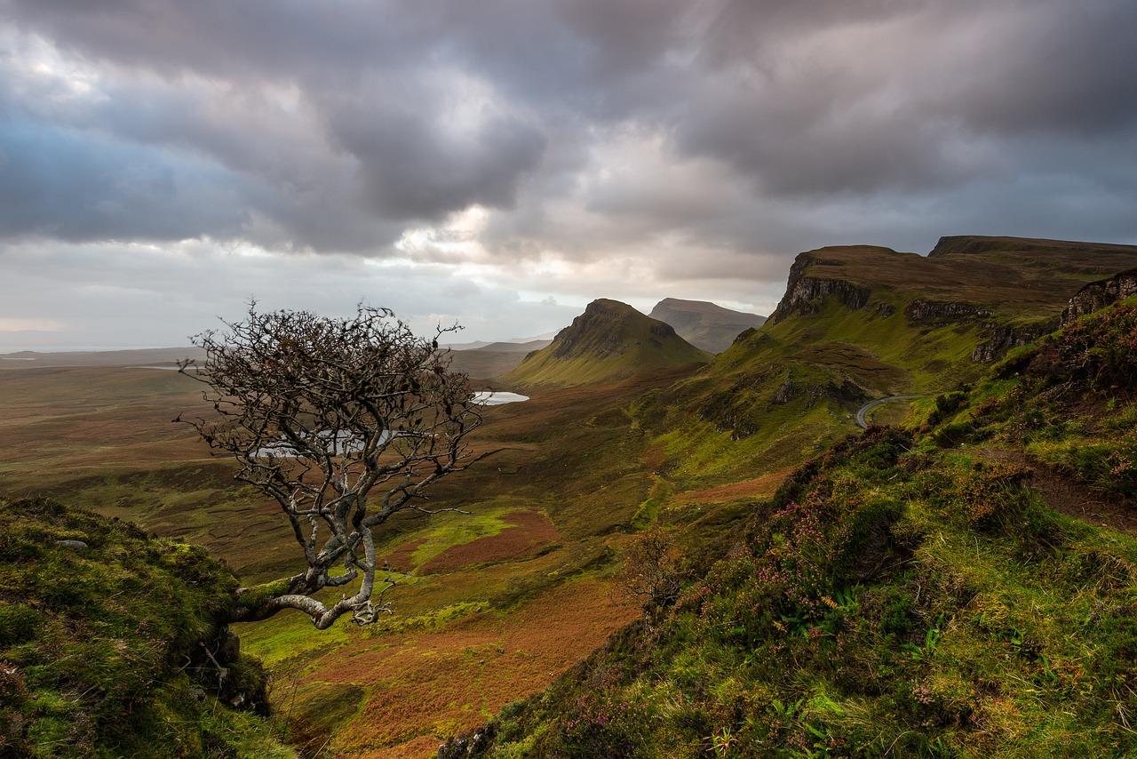 The Quiraing, a breathtaking landslip on the Isle of Skye, Scotland, features towering cliffs, rolling hills, and a winding path, showcasing the island's unique and rugged landscape. 