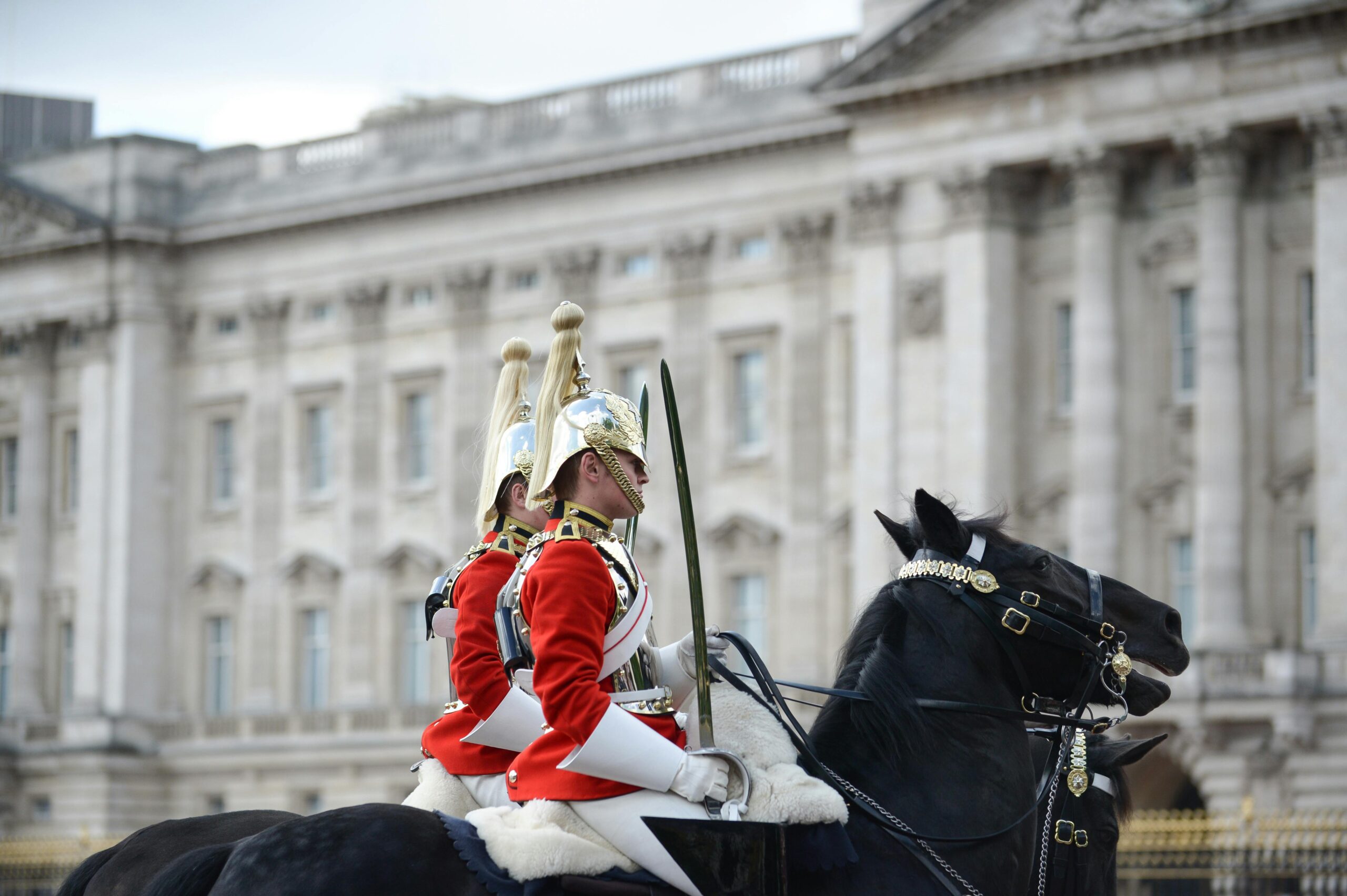 Two British Household Division guards ride majestic horses, showcasing tradition and pageantry. 