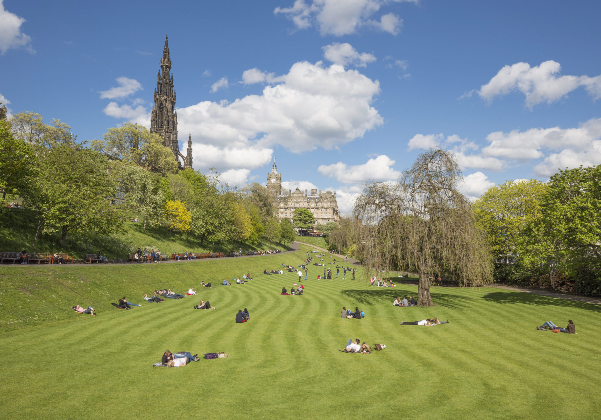 Edinburgh's Princes Street Gardens, a vibrant public park in the heart of the city, featuring beautiful gardens, walking paths, and the famous Scott Monument in the background.